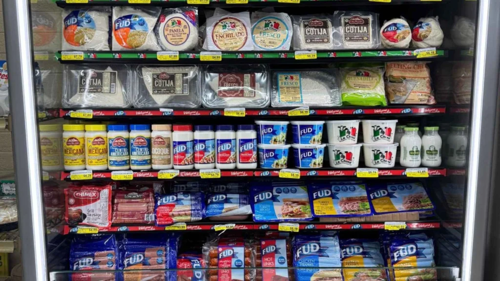 Cooler stocked with Mexican cheeses, crema and dairy under a Try Our Authentic Mexican Flavor sign at Butcher & Farmer Market in Buckeye, AZ.