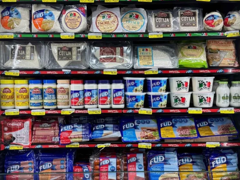 Cooler stocked with Mexican cheeses, crema and dairy under a Try Our Authentic Mexican Flavor sign at Butcher & Farmer Market in Buckeye, AZ.