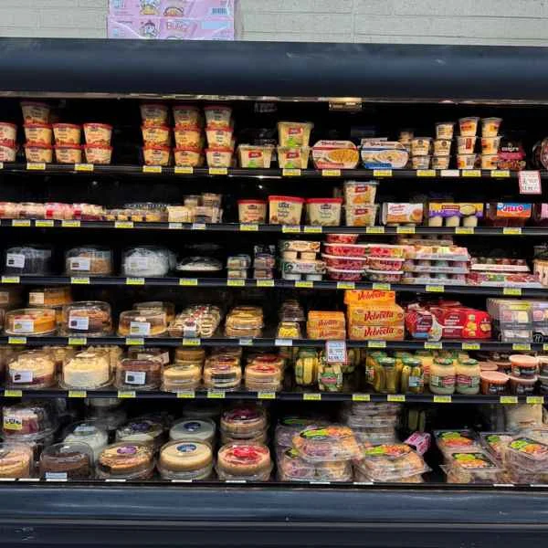 Refrigerated deli case with cheeses, dips, salads and grab-and-go items at Butcher & Farmer Market in Buckeye, AZ.
