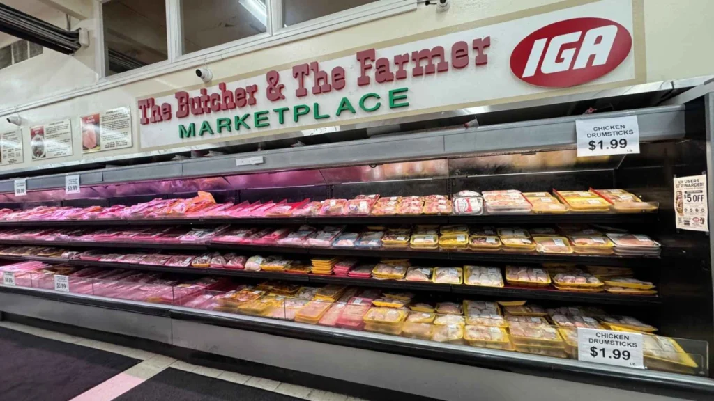 Long fresh meat case under the Butcher & The Farmer Marketplace sign at Butcher & Farmer Market in Buckeye, AZ.