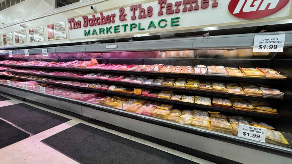 Fresh meat case stretching the length of the department under the store sign at Butcher & Farmer Market in Buckeye, AZ.