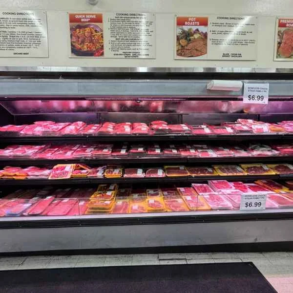 Shelves of fresh-cut meats in the full-service meat case at Butcher & Farmer Market in Buckeye, AZ.