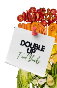 Double Up Food Bucks note pinned over fresh tomatoes, peppers, carrots, squash and greens, for the SNAP/EBT produce match at Butcher & Farmer Market in Buckeye, AZ
