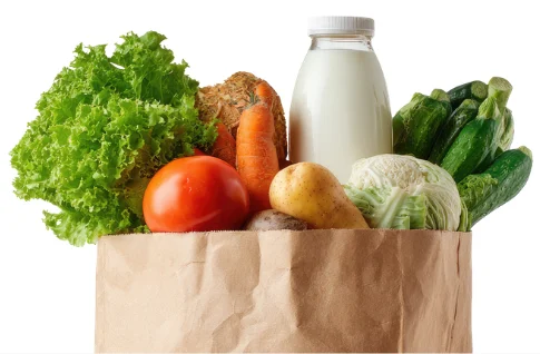 Paper grocery bag filled with fresh vegetables, bread and milk