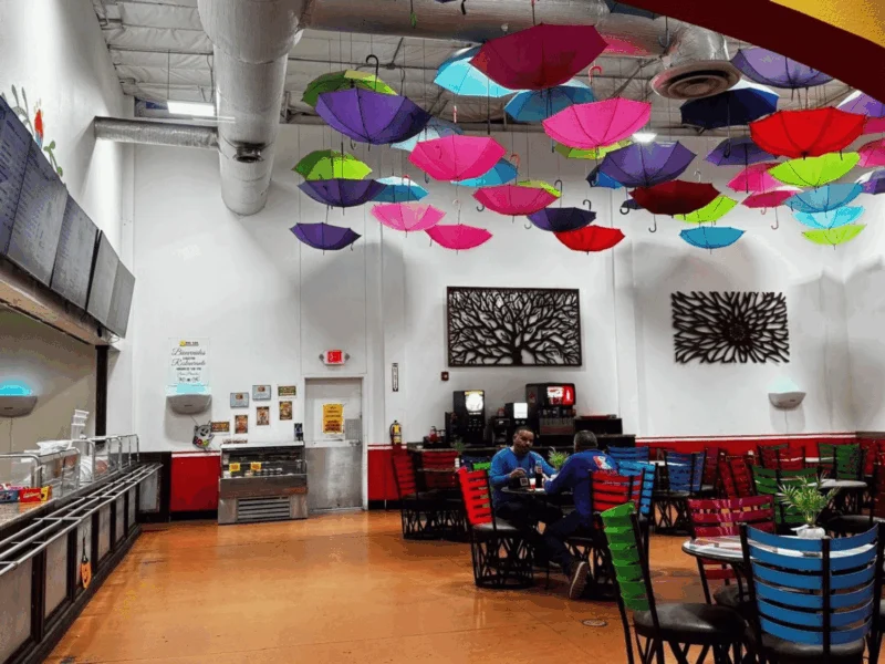 Restaurant dining area with colorful umbrellas hanging from the ceiling at Del Sol Market San Luis East in San Luis, AZ