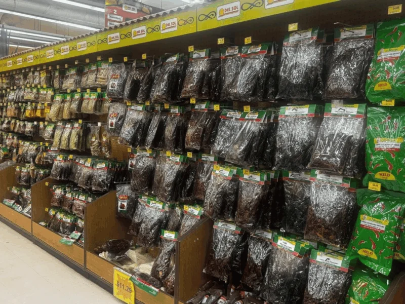 Grocery aisle stocked with bagged dried chiles and Mexican spices at Del Sol Market San Luis East in San Luis, AZ