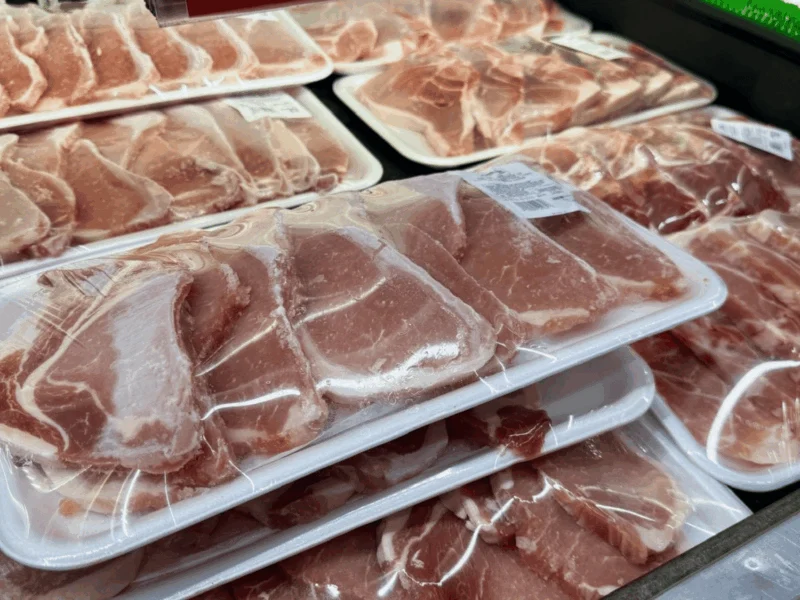 Packages of thinly sliced fresh meat in the meat case at Del Sol Market in San Luis, AZ