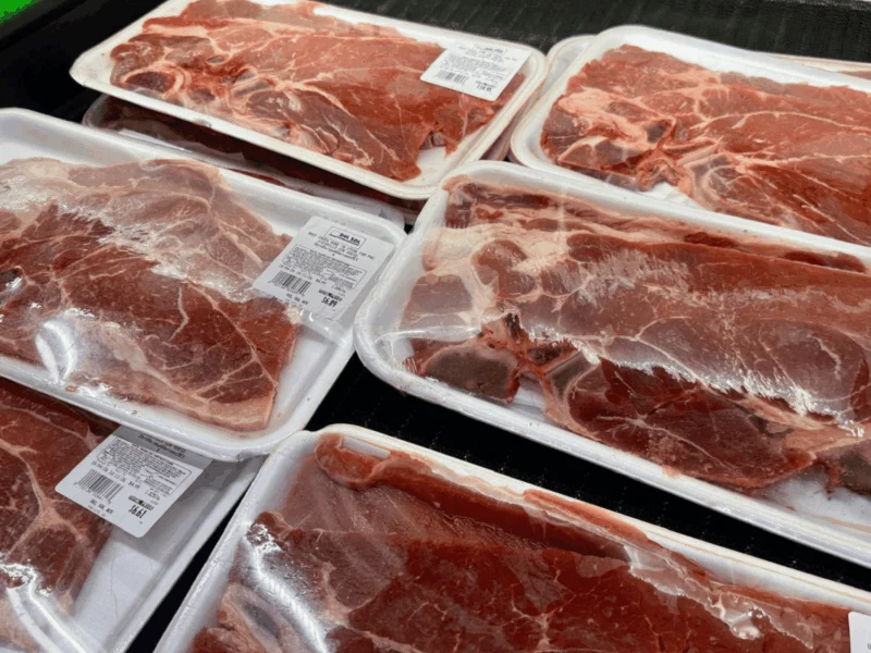 Packages of thinly sliced fresh meat in the meat case at Del Sol Market in San Luis, AZ