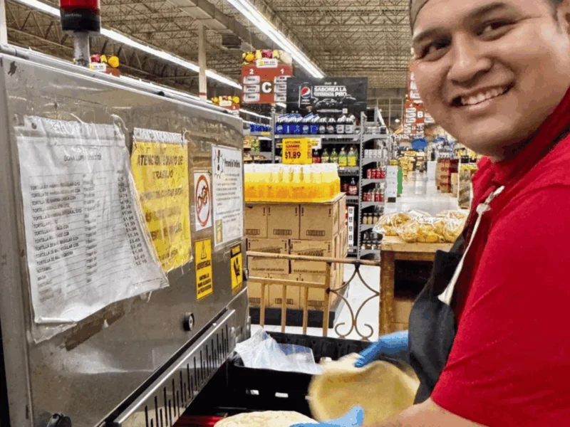 Smiling tortillería team member making fresh tortillas at Del Sol Market in San Luis, AZ