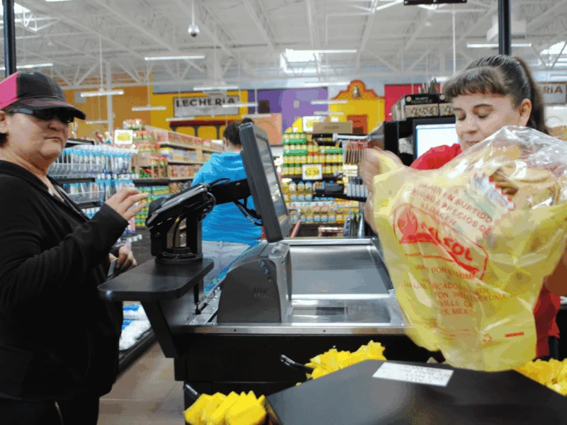 Cashier ringing up a customer at the checkout lane at Del Sol in Somerton, AZ