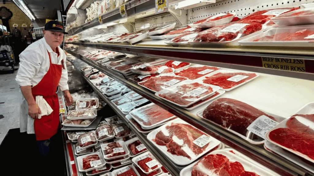 Butcher stocking fresh beef in the meat case at Del Sol on 16th Street in Yuma, AZ