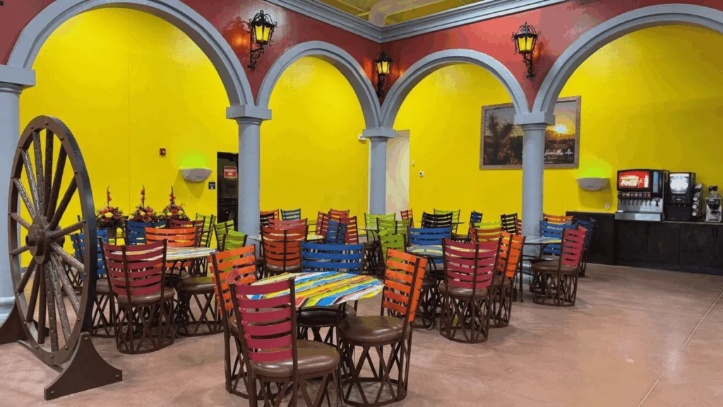 Hacienda-style restaurant dining room with arches and colorful chairs at Del Sol in the Yuma Foothills, AZ