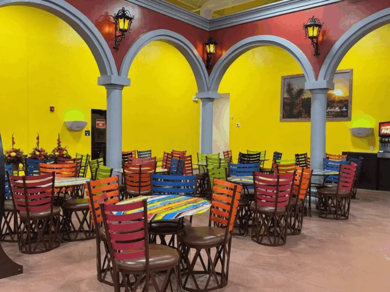 Hacienda-style restaurant dining room with arches and colorful chairs at Del Sol in the Yuma Foothills, AZ