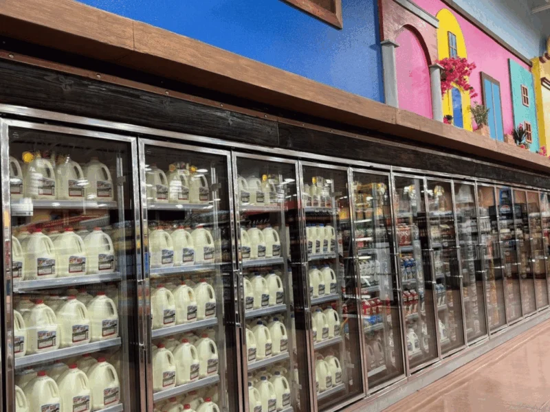 Dairy department with glass-door coolers and colorful wall décor at Del Sol in the Yuma Foothills, AZ