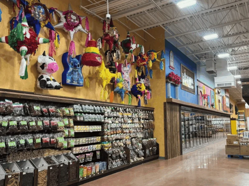 Colorful piñatas above an aisle of bulk dried chiles and spices at Del Sol in the Yuma Foothills, AZ