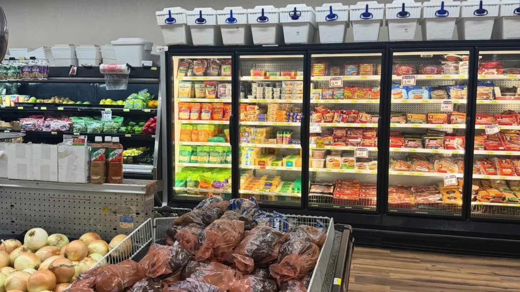 Refrigerated cases behind a bin of bagged potatoes at Food Town IGA in Eloy