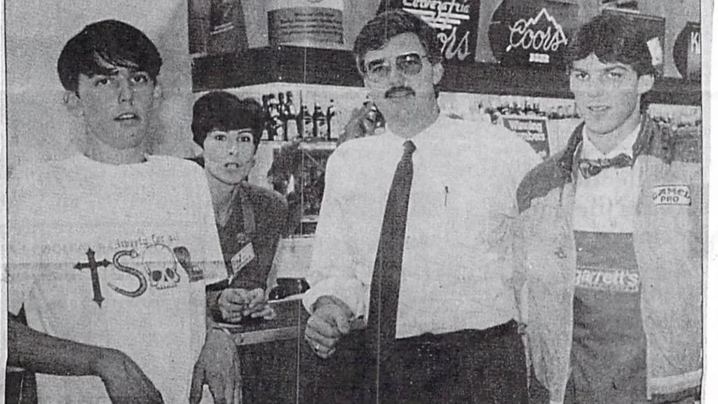 1986 newspaper photo of Ray Garrett with his wife Pam and sons Jeff and Michael inside Garrett's Supermarket