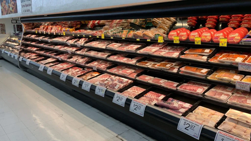 Long meat case with fresh beef, pork and chicken with price signs