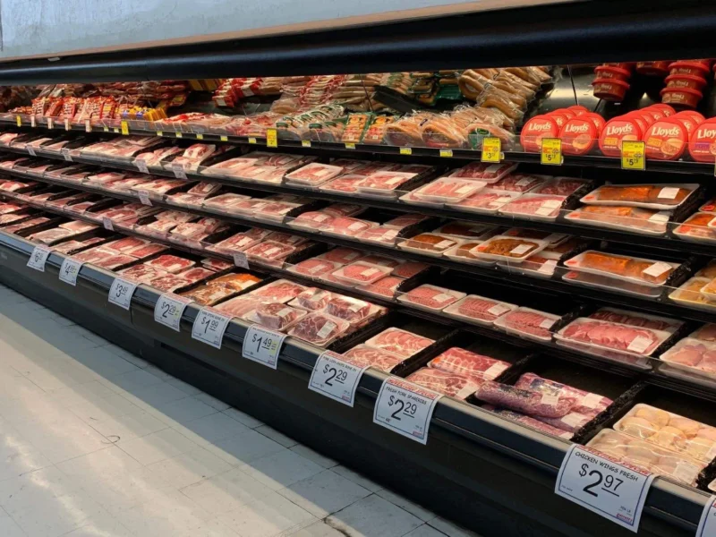 Long meat case with fresh beef, pork and chicken with price signs