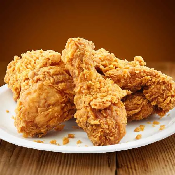 Crispy golden fried chicken pieces on a white plate