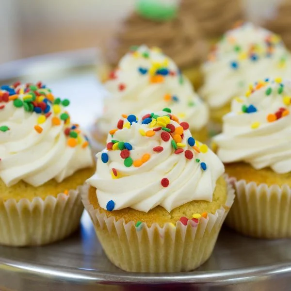 Cupcakes topped with swirled frosting and colorful sprinkles