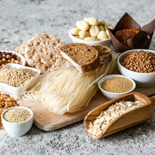 Gluten-free grains, rice noodles, rice cakes and muffins on a stone surface