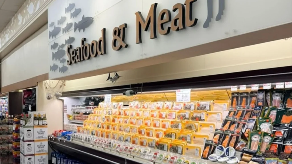 Seafood and Meat department sign above a case of packaged fresh seafood