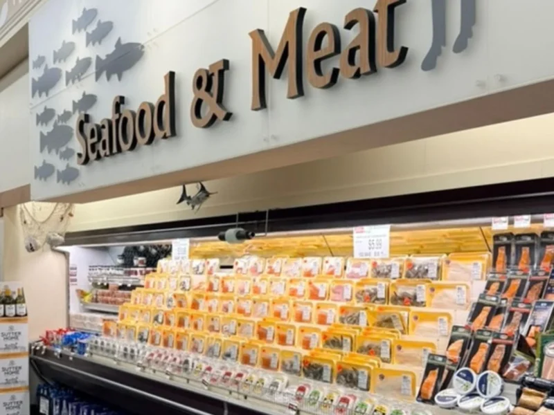 Seafood and Meat department sign above a case of packaged fresh seafood