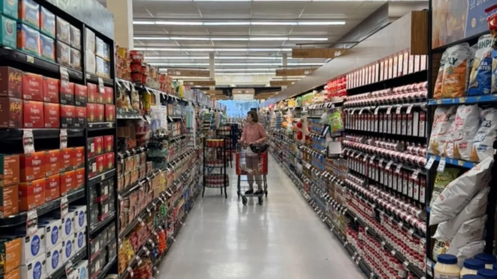 Shopper with a cart walking down a well-stocked grocery aisle at Keil's
