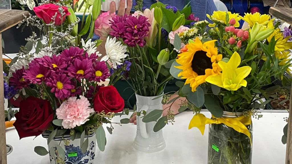 Fresh flower arrangements of roses, sunflowers, lilies, daisies and carnations in vases at Norm's IGA