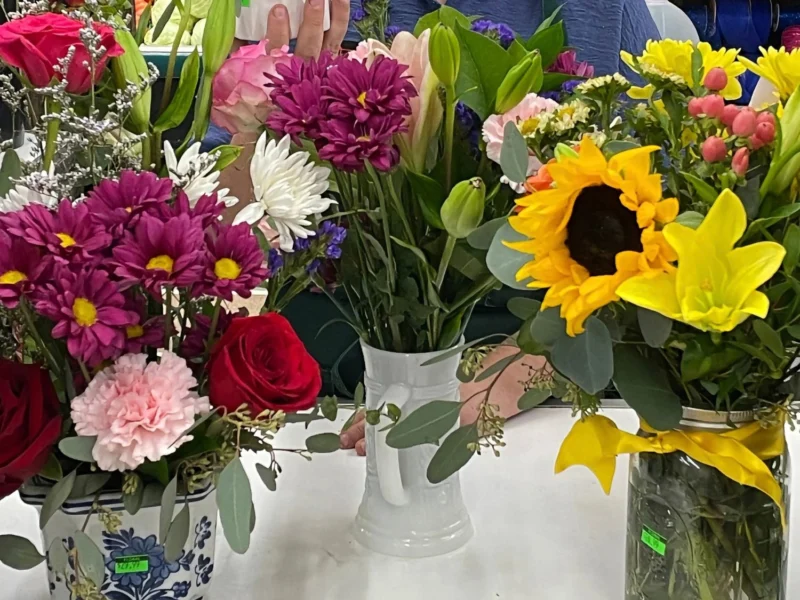 Fresh flower arrangements of roses, sunflowers, lilies, daisies and carnations in vases at Norm's IGA
