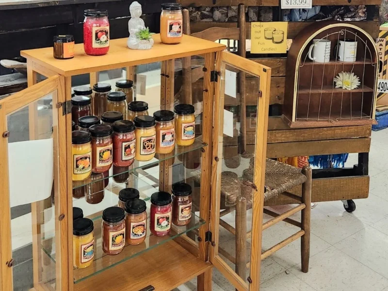 Jars of seasonings and spice blends in a wooden display cabinet