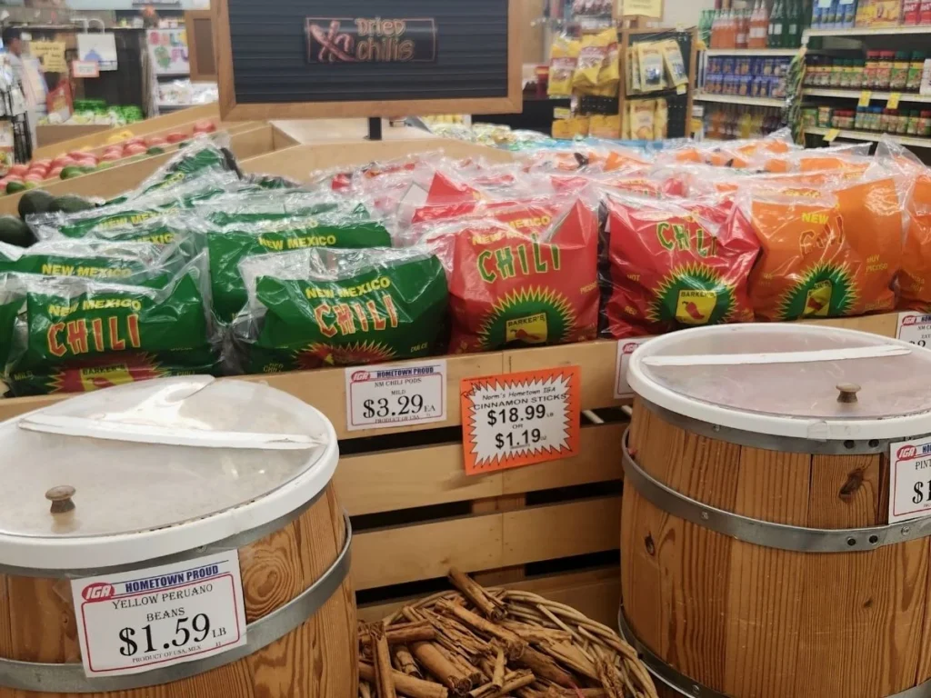 Bags of dried chiles and spices displayed in wooden barrels