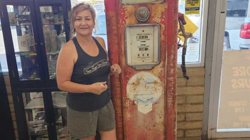 Myra Warren, co-owner of Norm's IGA, with a vintage Chevron gas pump from her grandparents' Gabe & Sons service station