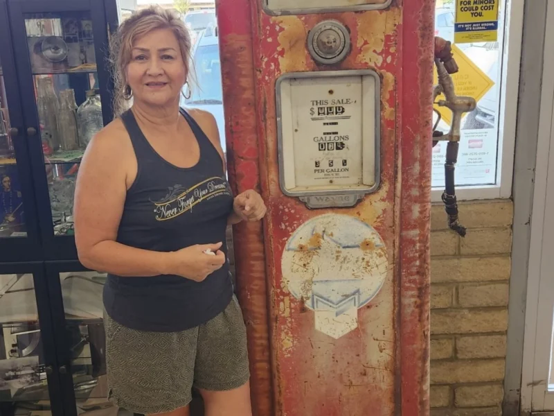 Myra Warren, co-owner of Norm's IGA, with a vintage Chevron gas pump from her grandparents' Gabe & Sons service station