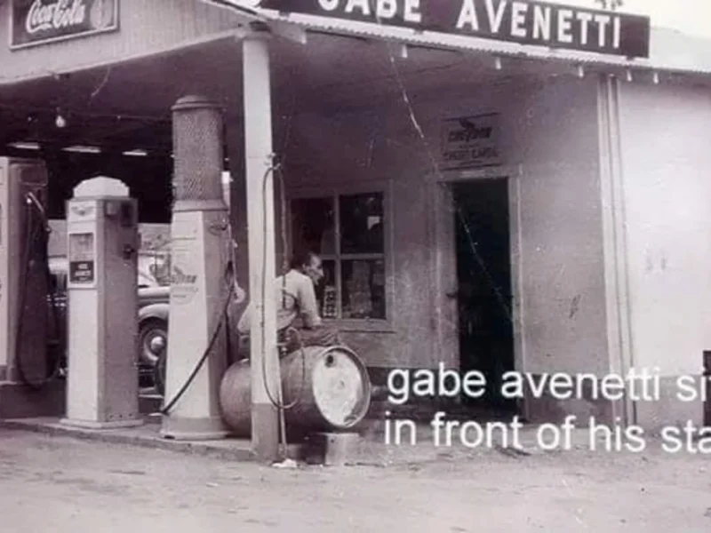 Historic photo of Gabe Avenetti sitting in front of his service station, with the original Chevron gas pump on the far left