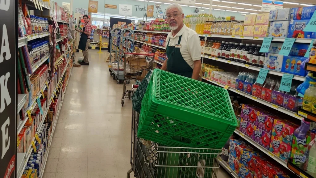 Norm's IGA team member with a cart in the aisle