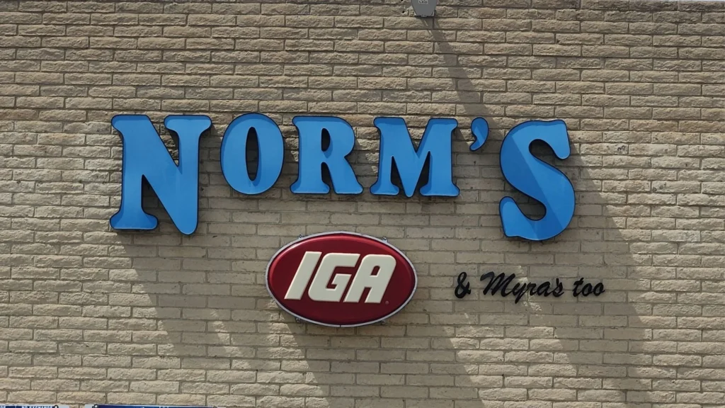 Norm's IGA and Myra's Too sign on the front of the store