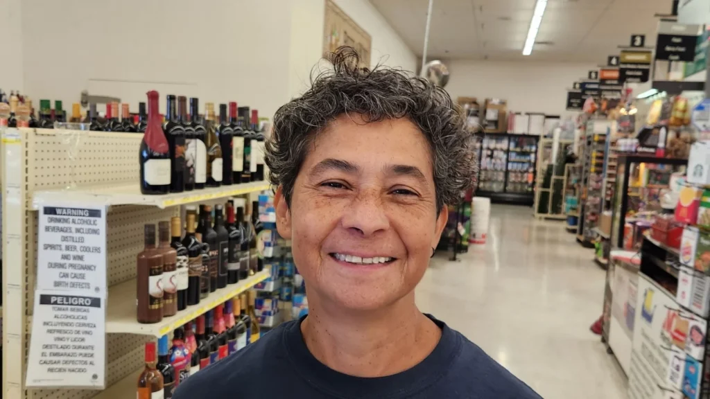 Smiling Olsens Marketplace employee in a Hometown IGA shirt