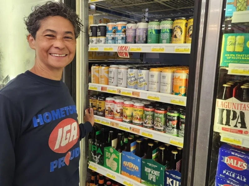 Smiling Olsens Marketplace employee in the beer and beverage aisle