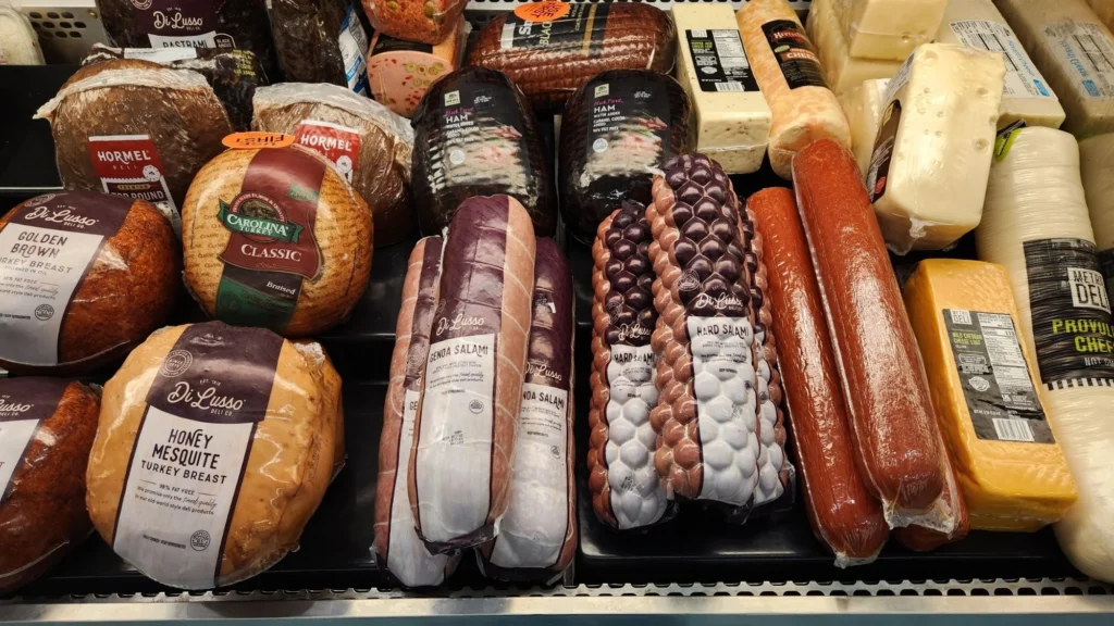 Deli case with sliced meats, sausages and cheeses at Olsens Marketplace