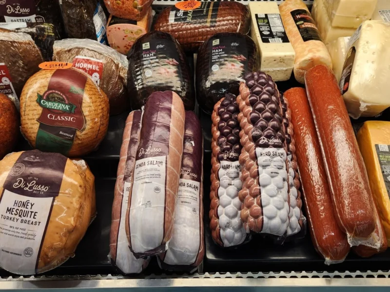 Deli case with sliced meats, sausages and cheeses at Olsens Marketplace