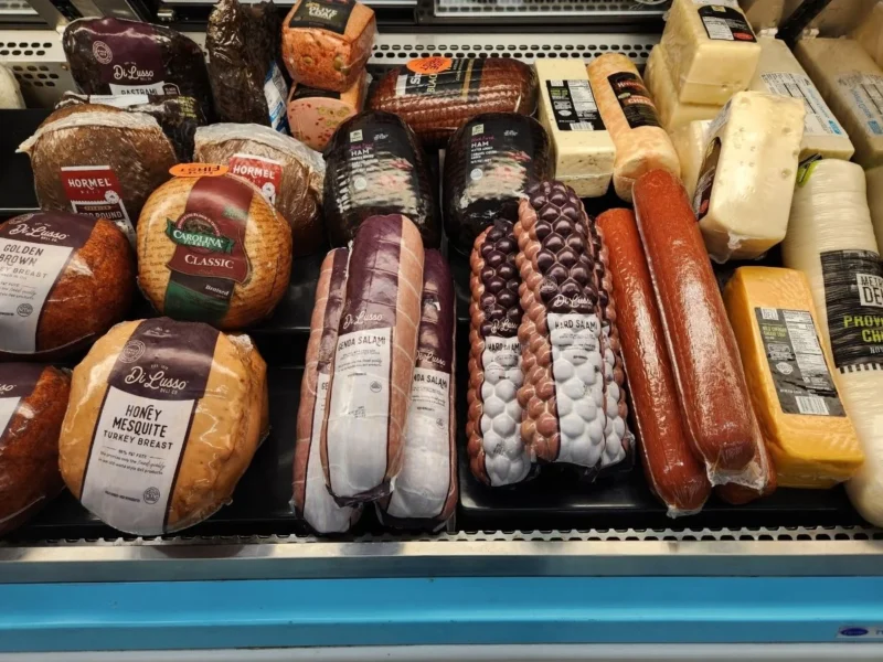 Deli case with sliced meats, sausages and cheeses at Olsens Marketplace