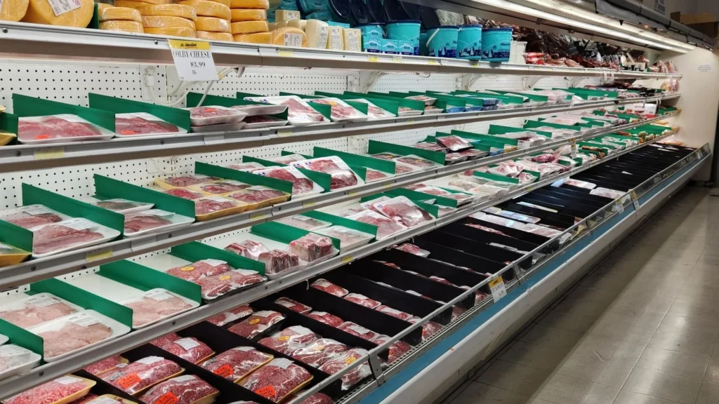 Long refrigerated meat case stocked with fresh cuts at Olsens Marketplace