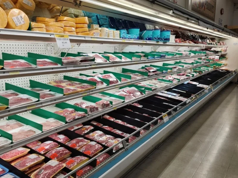 Long refrigerated meat case stocked with fresh cuts at Olsens Marketplace