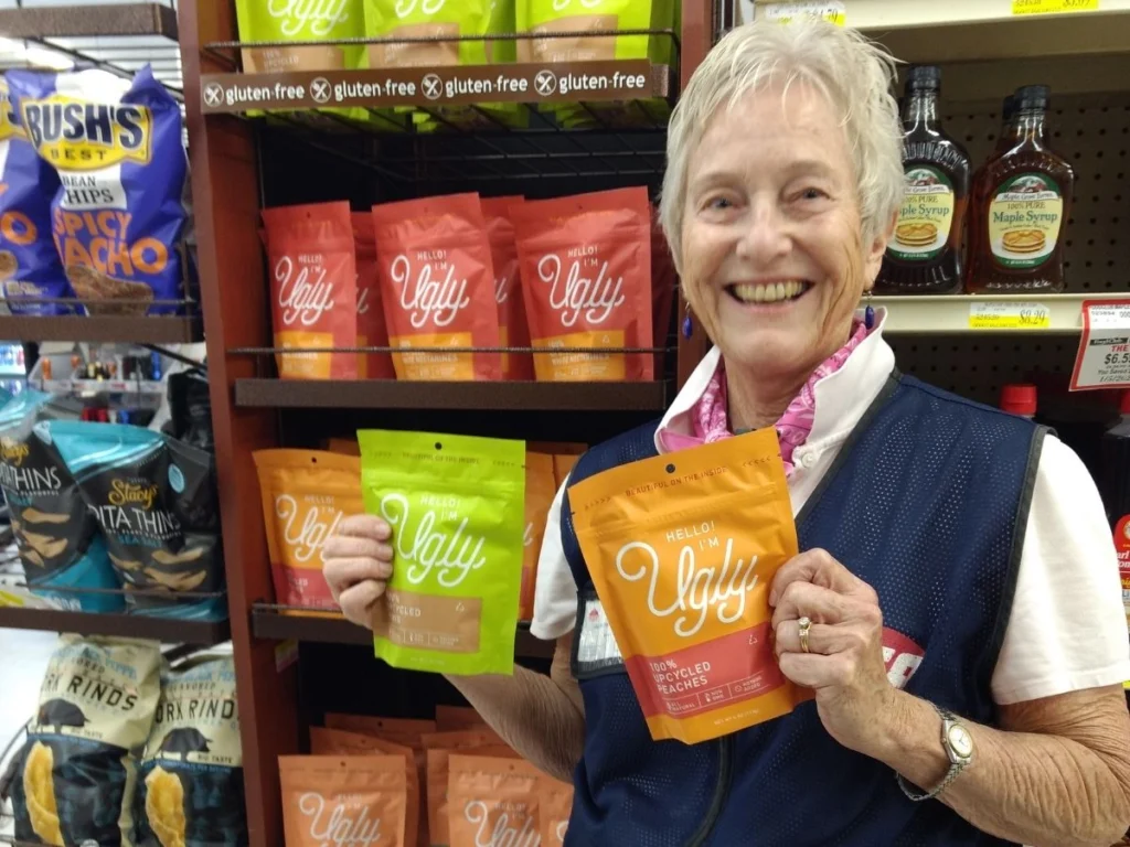 Smiling Olsens Marketplace employee holding bags of specialty spices