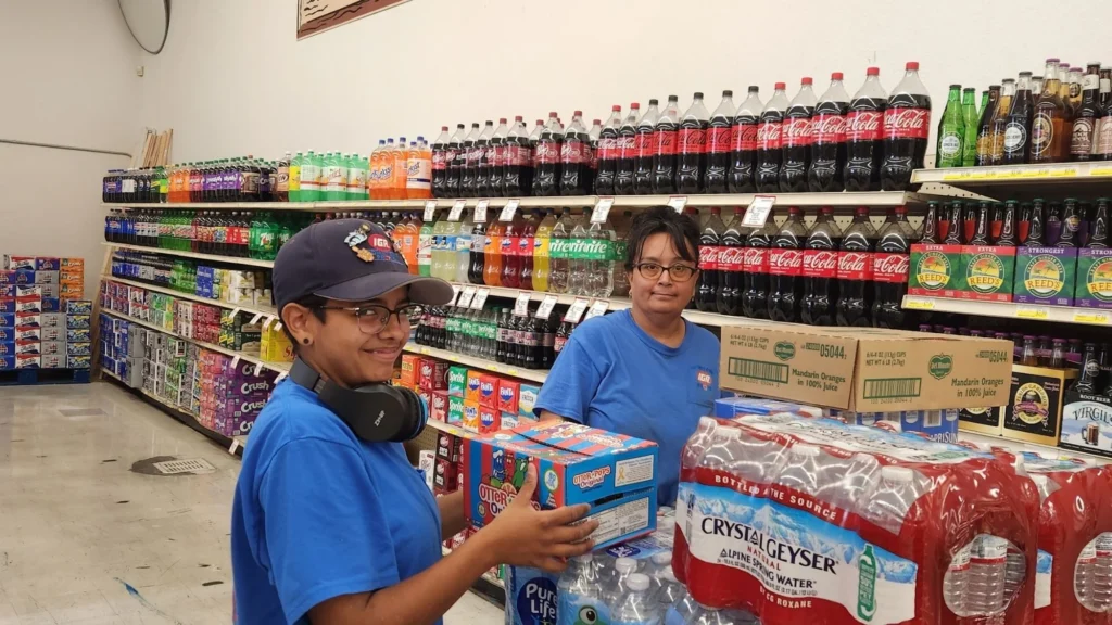 Olsens Marketplace employees stocking soda and bottled water