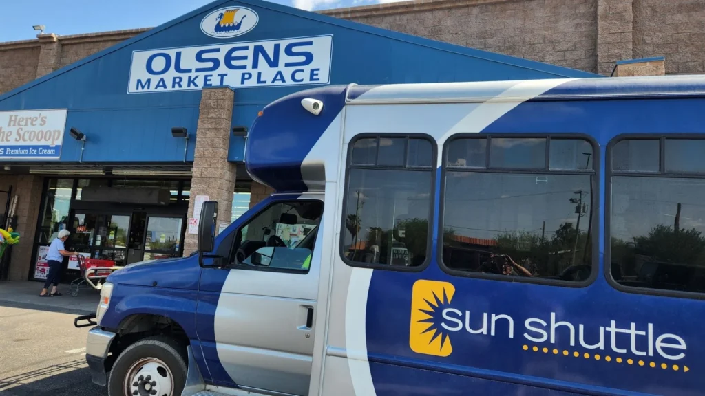 Sun Shuttle bus stopped in front of Olsens Marketplace IGA