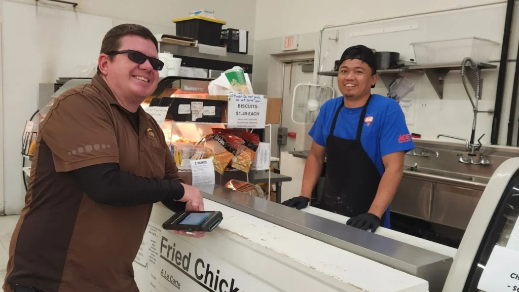 Customer ordering from an Olsens Patio Cafe employee at the counter