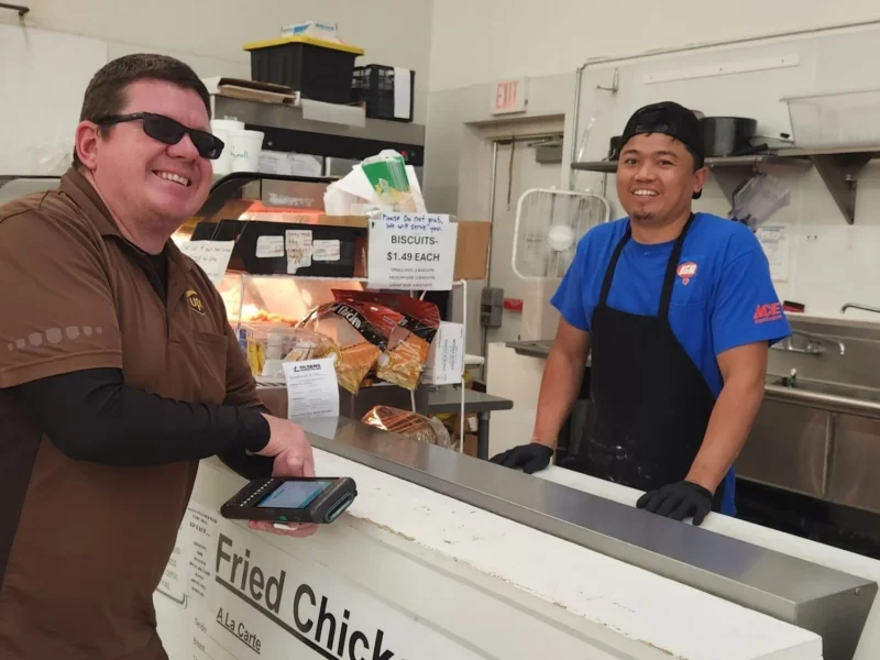 Customer ordering from an Olsens Patio Cafe employee at the counter